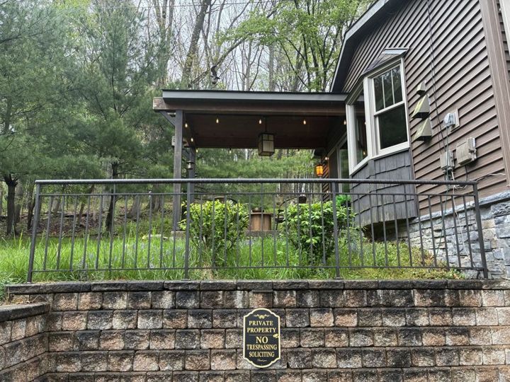 Bronze aluminum railing with a pipe top rail along a retaining wall